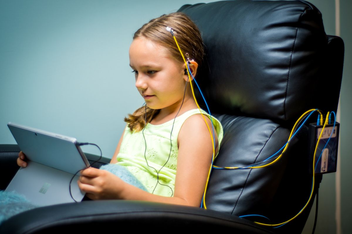 A practitioner adjusting neurofeedback sensors